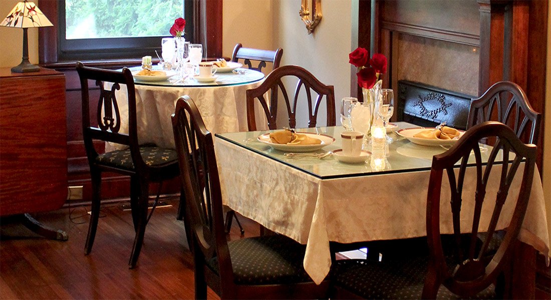 Dining room with two tables in front of fireplace